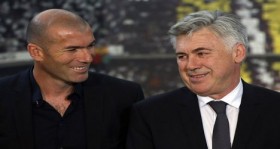 New Real Madrid coach Ancelotti smiles next to former soccer player Zidane as they pose during his official presentation at Santiago Bernabeu stadium in Madrid